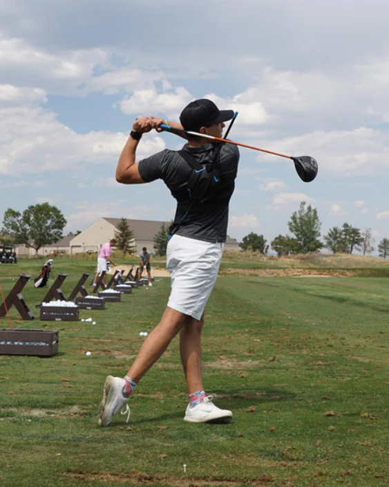 a man using BAKBON golf posture device on a golf course