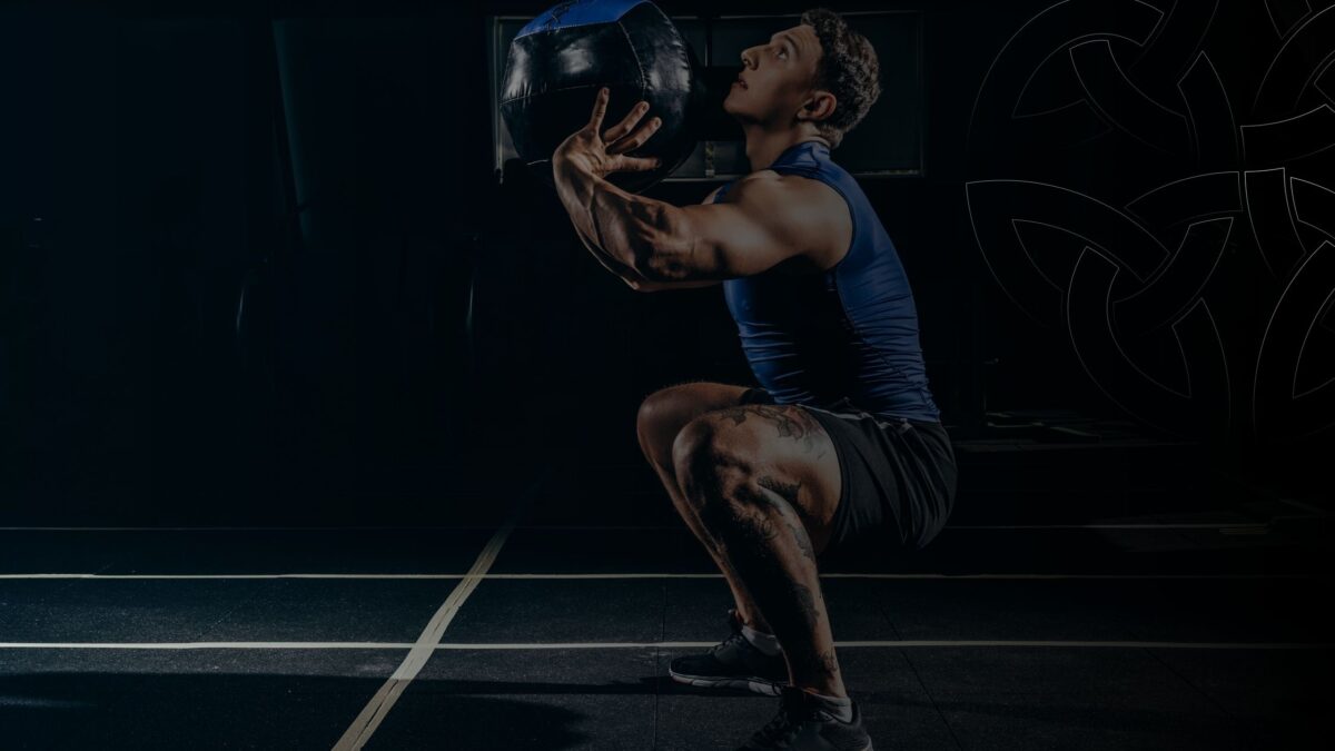 Athlete doing weight squats How Recovery Improves Consistency Across All Sports header